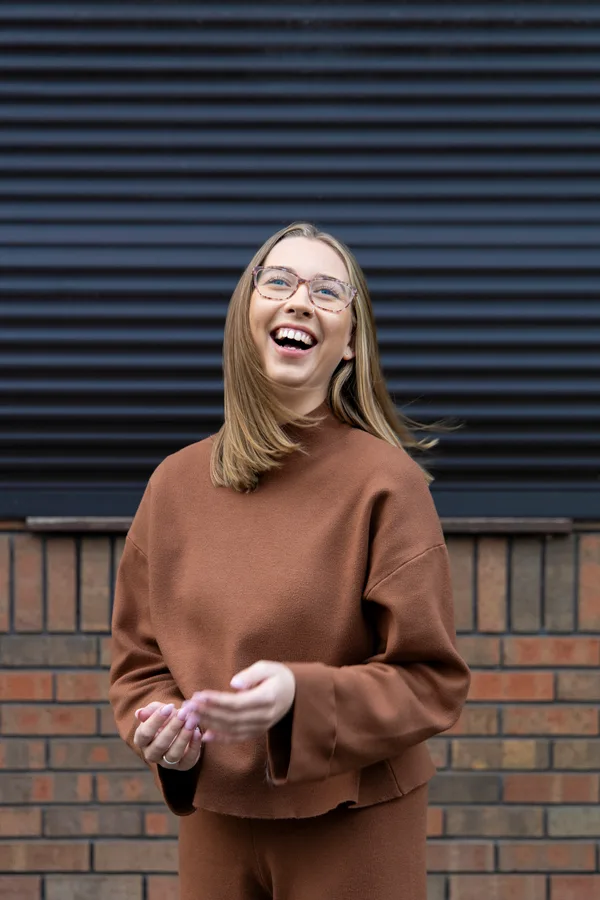 A Double Glazing Leads team member laughing outside the office